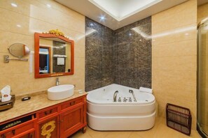 Ein modernes Badezimmer mit einer großen Badewanne, einem runden Spiegel und einem Waschtisch mit Waschbecken.