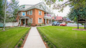A two-story brick house with a porch, a driveway, and a sign indicating a bed and breakfast. - Heber Senator Bed and Breakfast (Heber City)