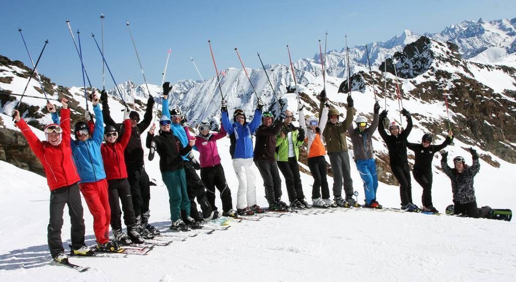 A group of skiers on a snowy mountain with ski equipment.