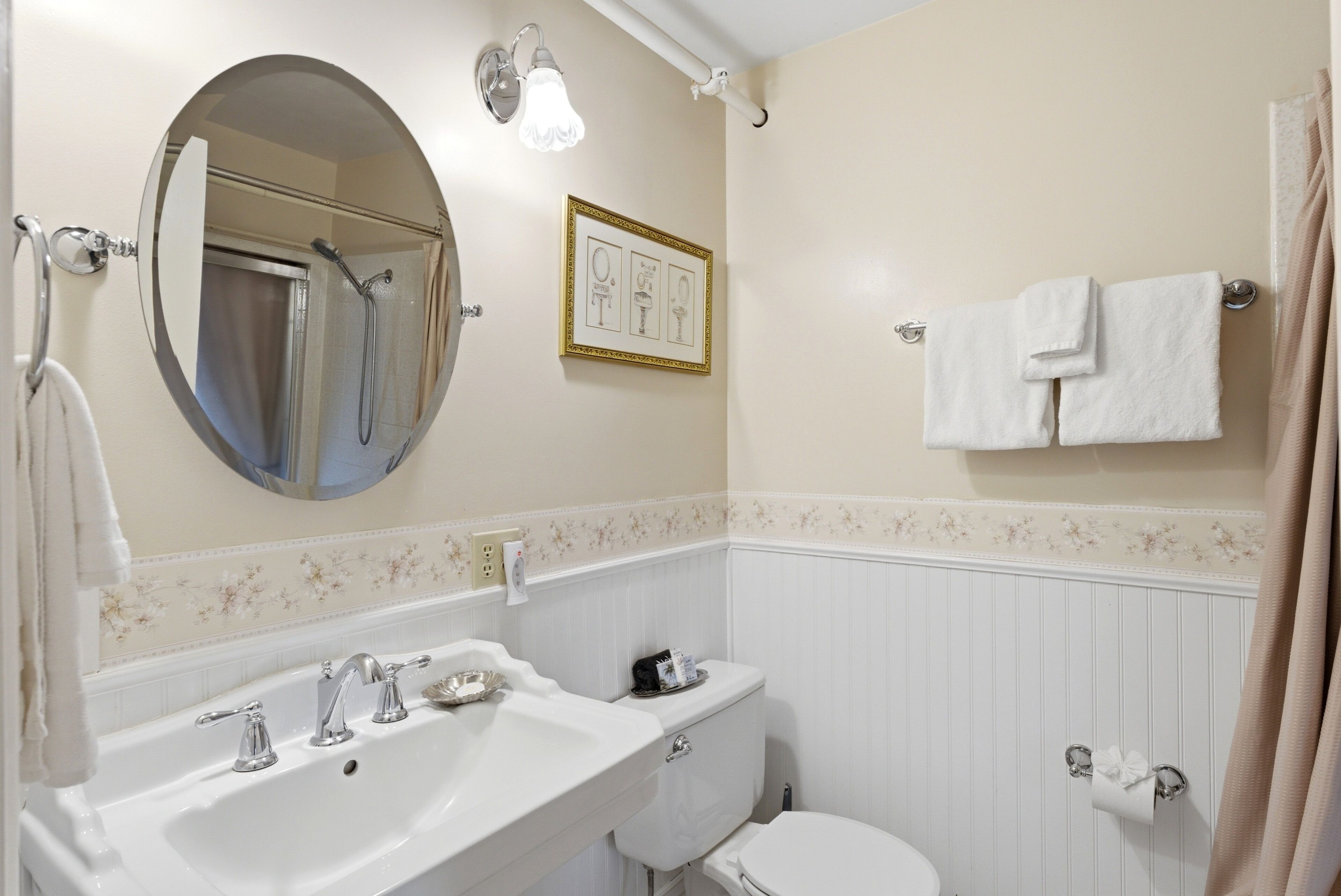 A bathroom with a sink, mirror, toilet, and towel rack.