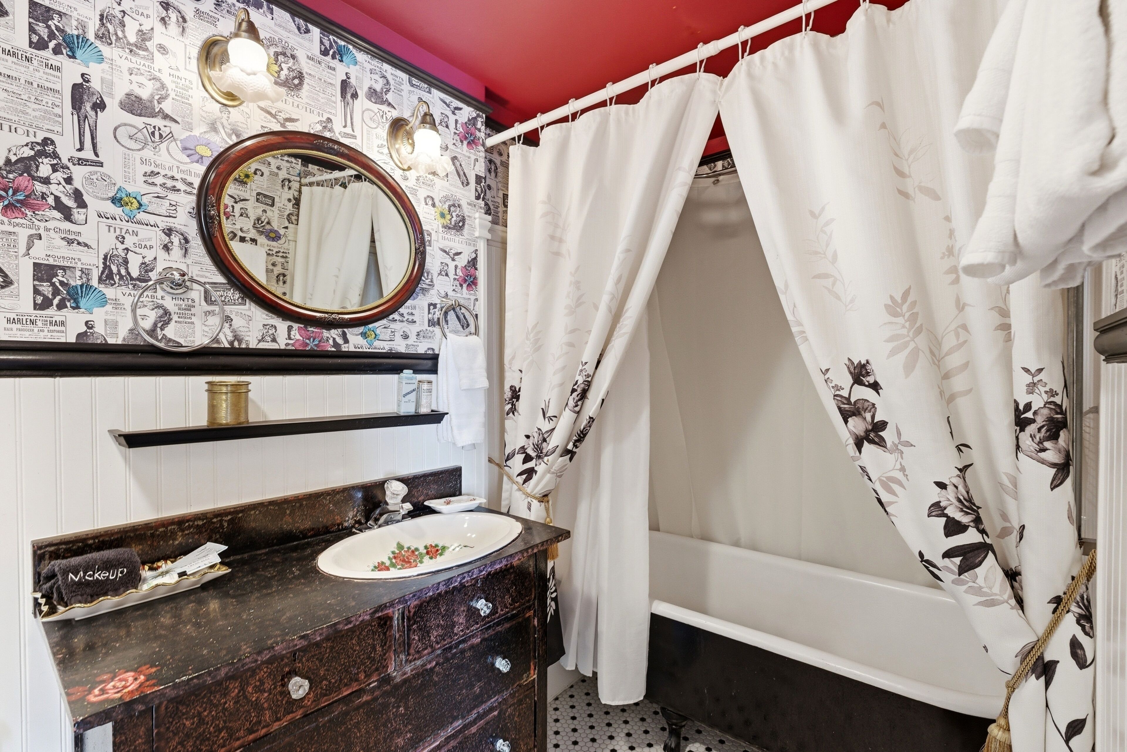 Une salle de bain avec un meuble-lavabo, un miroir et un rideau de douche.