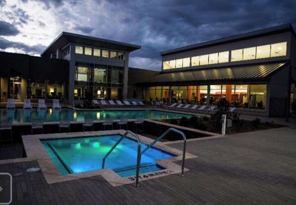 Relax by the pool surrounded by lounge chairs and a covered deck.