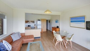 A compact living space with a kitchenette, a dining area, and a seating area with a sofa and chairs.