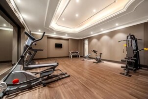 Un gimnasio con cintas de correr, bicicletas estáticas y máquinas de pesas.