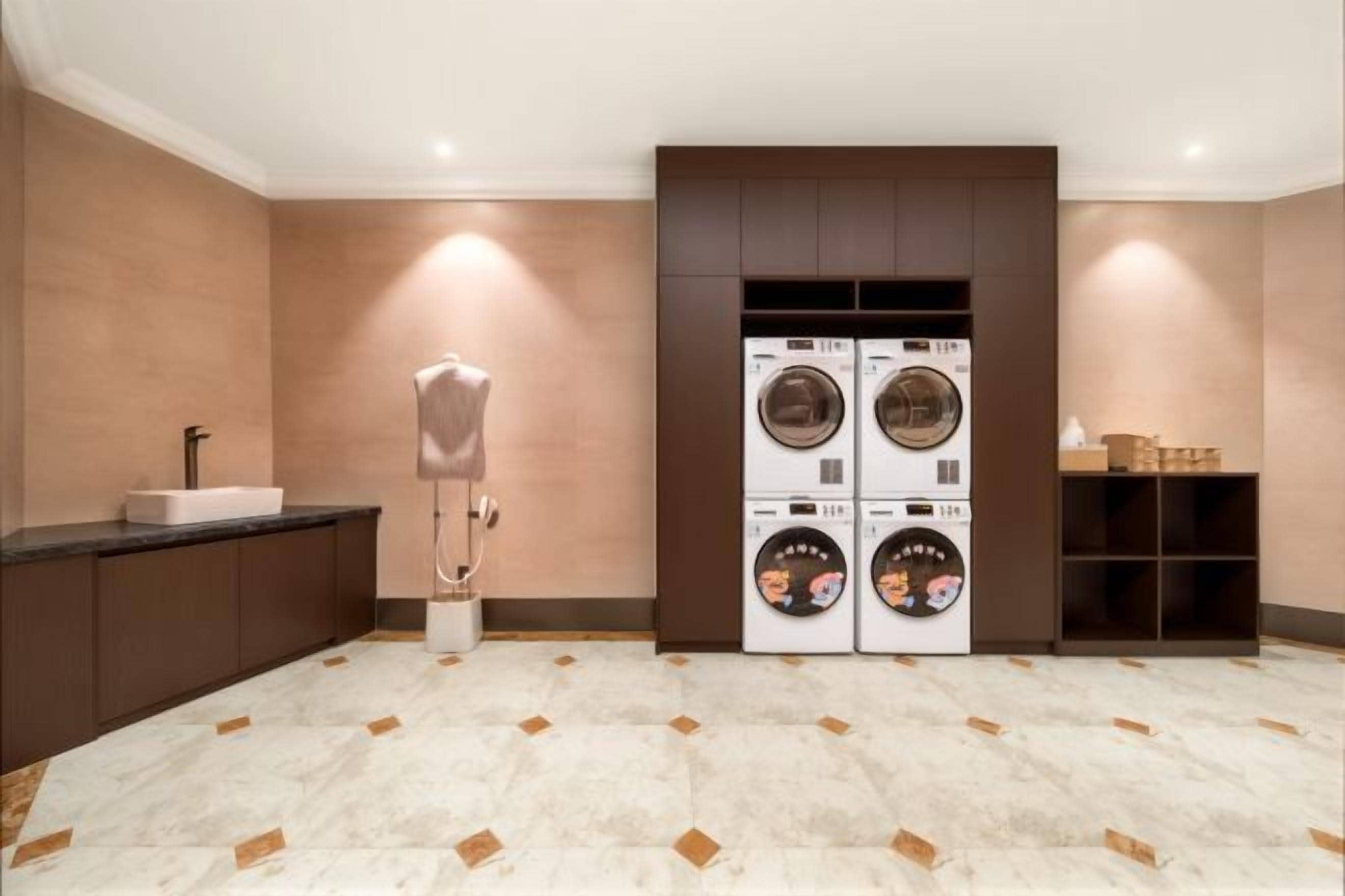 A laundry room with a washing machine and dryer, a sink, and a cabinet.