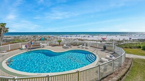 Ein Schwimmbecken mit Blick auf Strand und Meer.