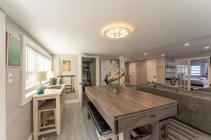 Un espacio habitable compacto con una mesa de comedor, un sofá, un globo terráqueo y una lámpara.