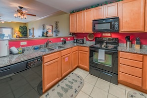 Enjoy cooking in this well-equipped kitchen with a granite countertop, stainless steel appliances, and wooden cabinetry.