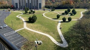 Un hôtel doté d’un parking, de jardins aménagés et offrant une vue sur les montagnes en arrière-plan.