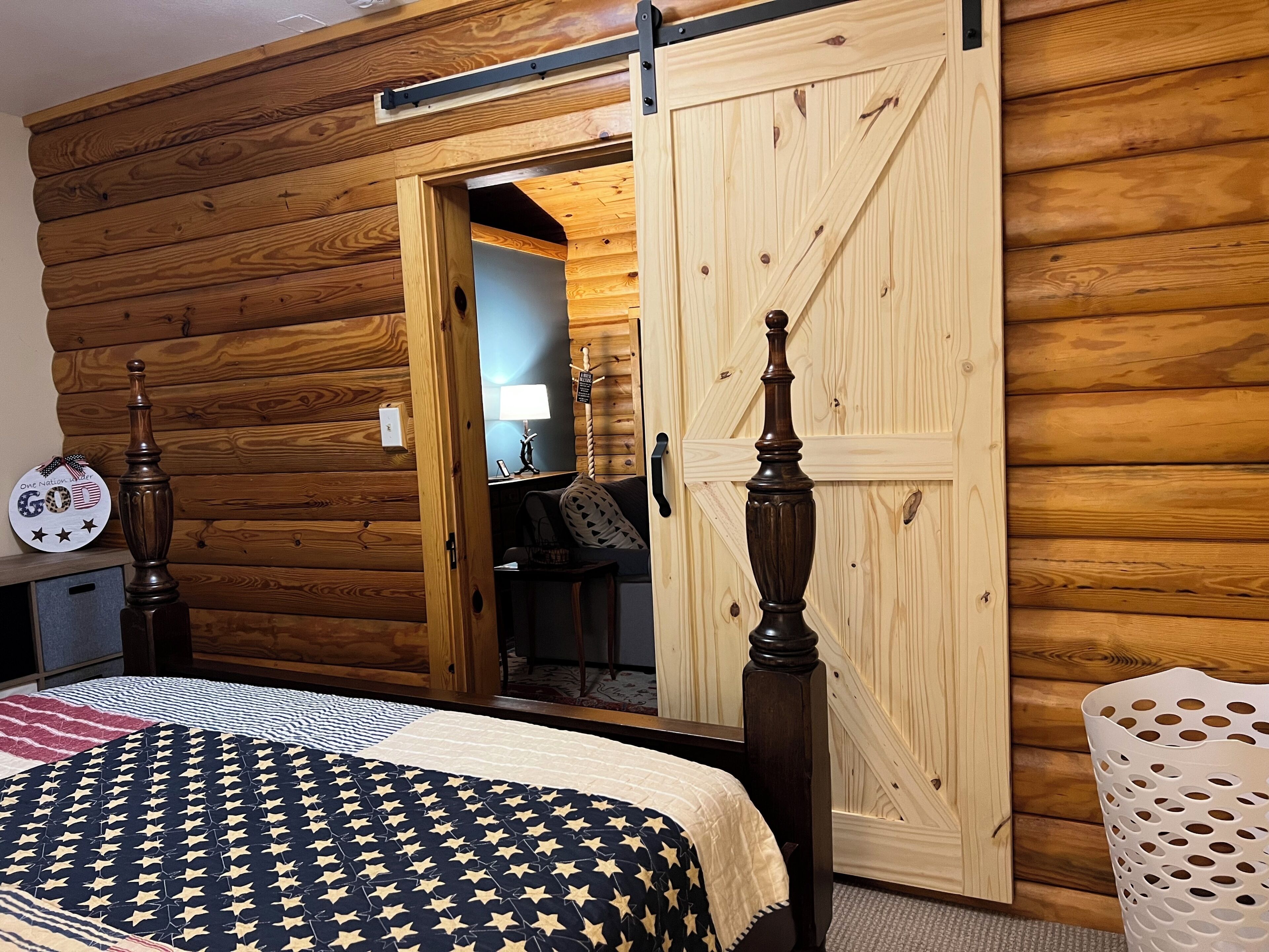Een kamer met een bed, een houten deur, een lamp en een muur met een houten paneeldecor.