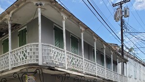 Un bâtiment à deux étages doté d’un balcon, de volets verts et d’une enseigne indiquant « Hamas Specialties ».
