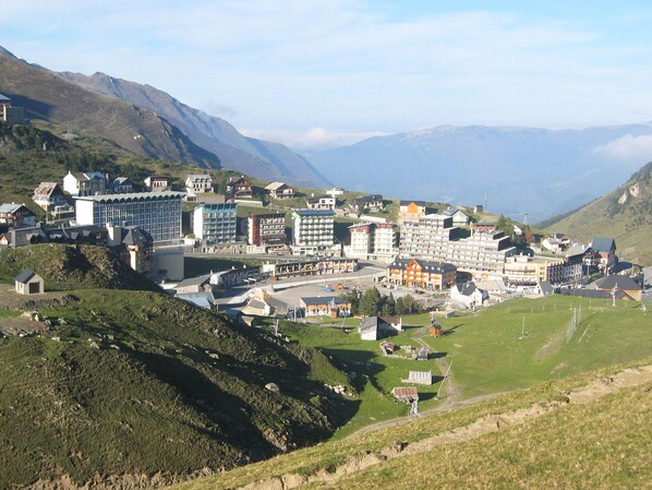 A mountainous town with a variety of buildings, including hotels and residential structures, set against a backdrop of hills and mountains.