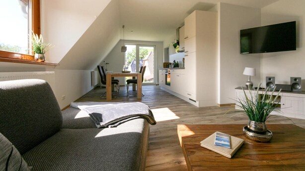 Un appartement moderne comprenant un coin repas, une cuisine et un salon.