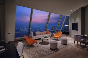 A modern living room with a city view, a sofa, two armchairs, a coffee table, and a floor lamp. - Niccolo Suzhou (Suzhou)