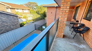 A balcony with a pool, outdoor seating, and a view of neighboring houses. - Cameo Court Unit 7 - South West Rocks (SOUTH WEST ROCKS)