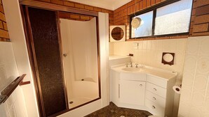 Un baño con ducha, lavamanos e inodoro.