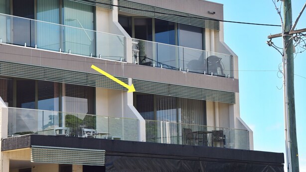 A multi-story building with balconies, large windows, and a visible yellow arrow pointing to a feature on the building. - Ocean View 1 - South West Rocks - Bring your own linen (SOUTH WEST ROCKS)