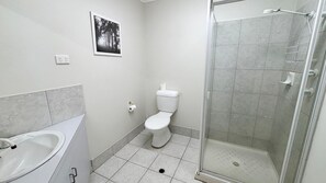 A bathroom with a toilet, a sink, and a shower area. - Ocean View 1 - South West Rocks (SOUTH WEST ROCKS)