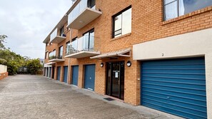 A row of brick buildings with blue garage doors, numbered 2, and a small sign on the door. - Woody Wonder Unit 2 - South West Rocks (SOUTH WEST ROCKS)