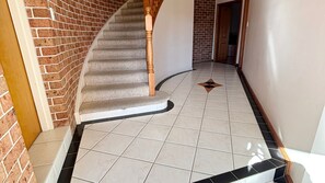 A staircase with a wooden handrail leading to a door, surrounded by a brick wall and a tiled floor. - Horizons - South West Rocks (SOUTH WEST ROCKS)