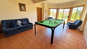 A room with a pool table, a blue sofa, and a chair. - Horizons - South West Rocks (SOUTH WEST ROCKS)