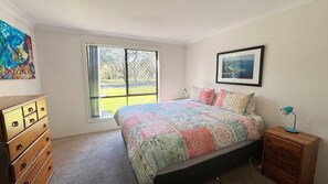 A bedroom with a bed, dresser, window, and artwork. - Parkside # 1 - South West Rocks (South West Rocks)