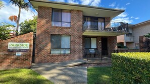 A brick apartment building with a sign for 'PARKSIDE HOLIDAY APARTMENTS' and a contact number. - Parkside # 1 - South West Rocks (South West Rocks)