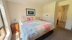 A bedroom with a bed, a nightstand, a lamp, a wardrobe, and a framed picture on the wall. - Parkside # 1 - South West Rocks - Bring your own linen (South West Rocks)