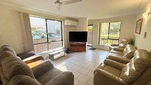 A living room with a flat-screen TV, leather sofas, and large windows. - Parkside # 1 - South West Rocks (South West Rocks)