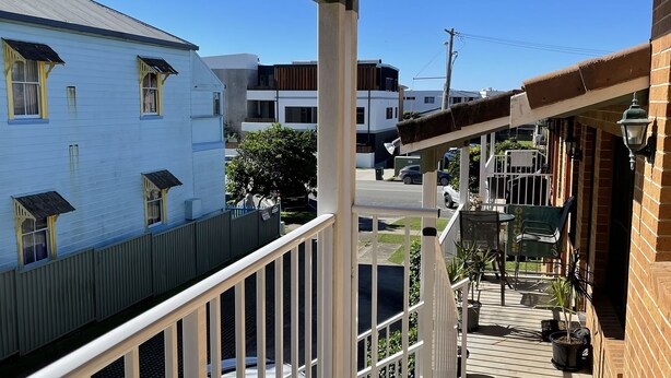 A residential area with a wooden deck, a white house, and a brick building. - Dunbar Court Unit 7 - South West Rocks (SOUTH WEST ROCKS)