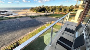 A balcony with a view of a beach and ocean.