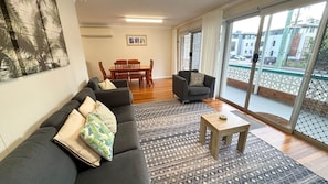 Un salon comprenant un canapé, une table basse et un coin repas avec des chaises et une table.