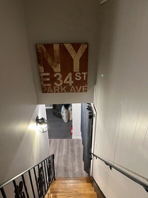 Una escalera que conduce a un segundo piso, con un cartel que indica "NY 34 ST PARK AVE".