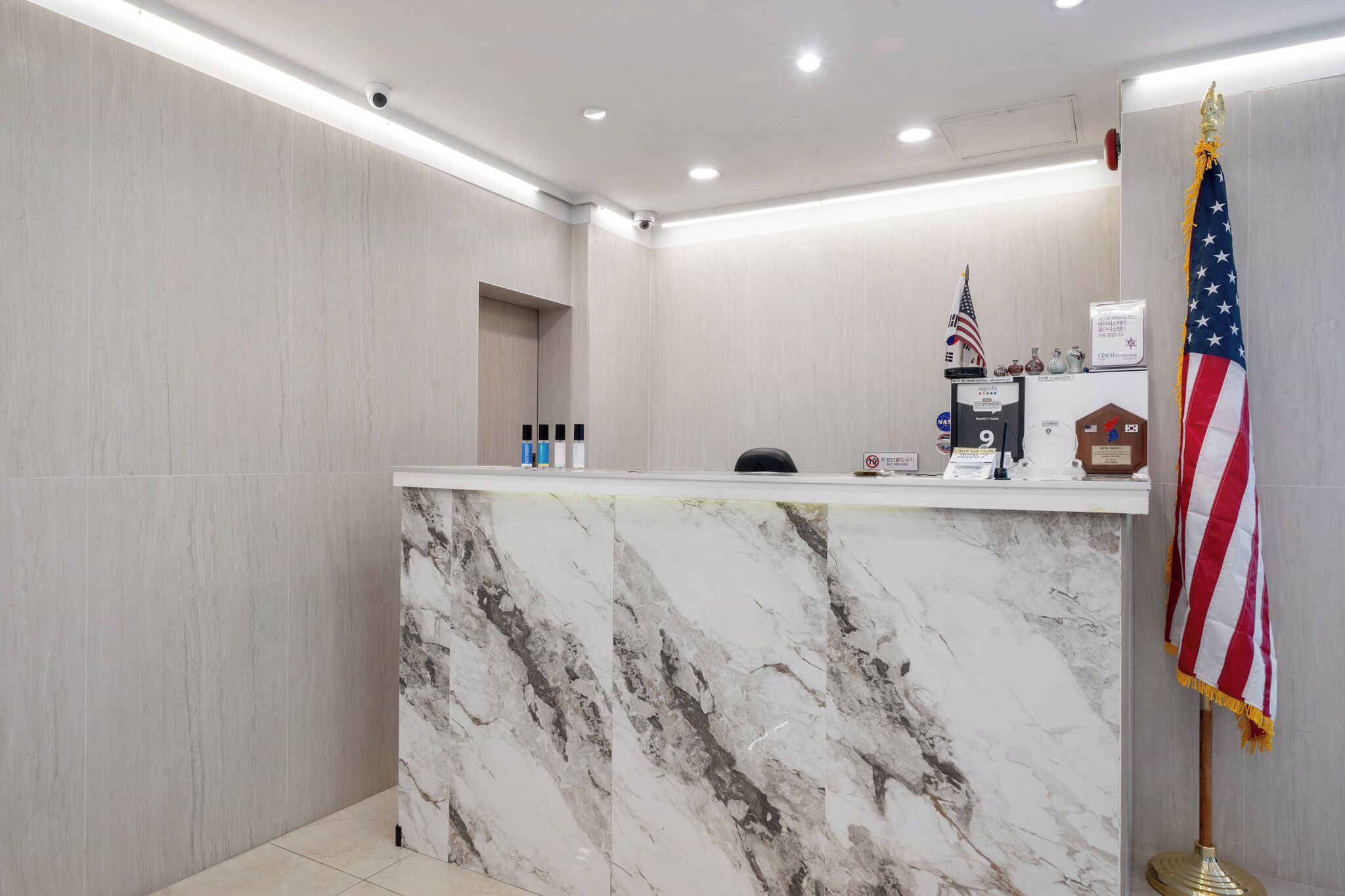 A reception desk with a marble top, an American flag, and a plaque.