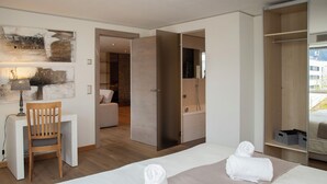 A hotel room with a bed, a desk, a chair, a wardrobe, and a bathroom visible through an open door. - Chesa Piz Padella - St. Moritz by Interhome (St. Moritz)