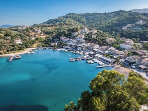 A coastal town with a marina, houses, and hilly terrain.