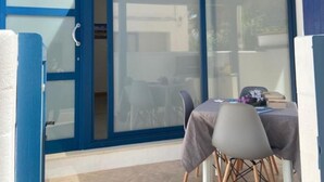 A room with a sliding glass door leading to an outdoor area with a table and chairs. - Apartment Mare by Interhome (Santa Croce Camerina)