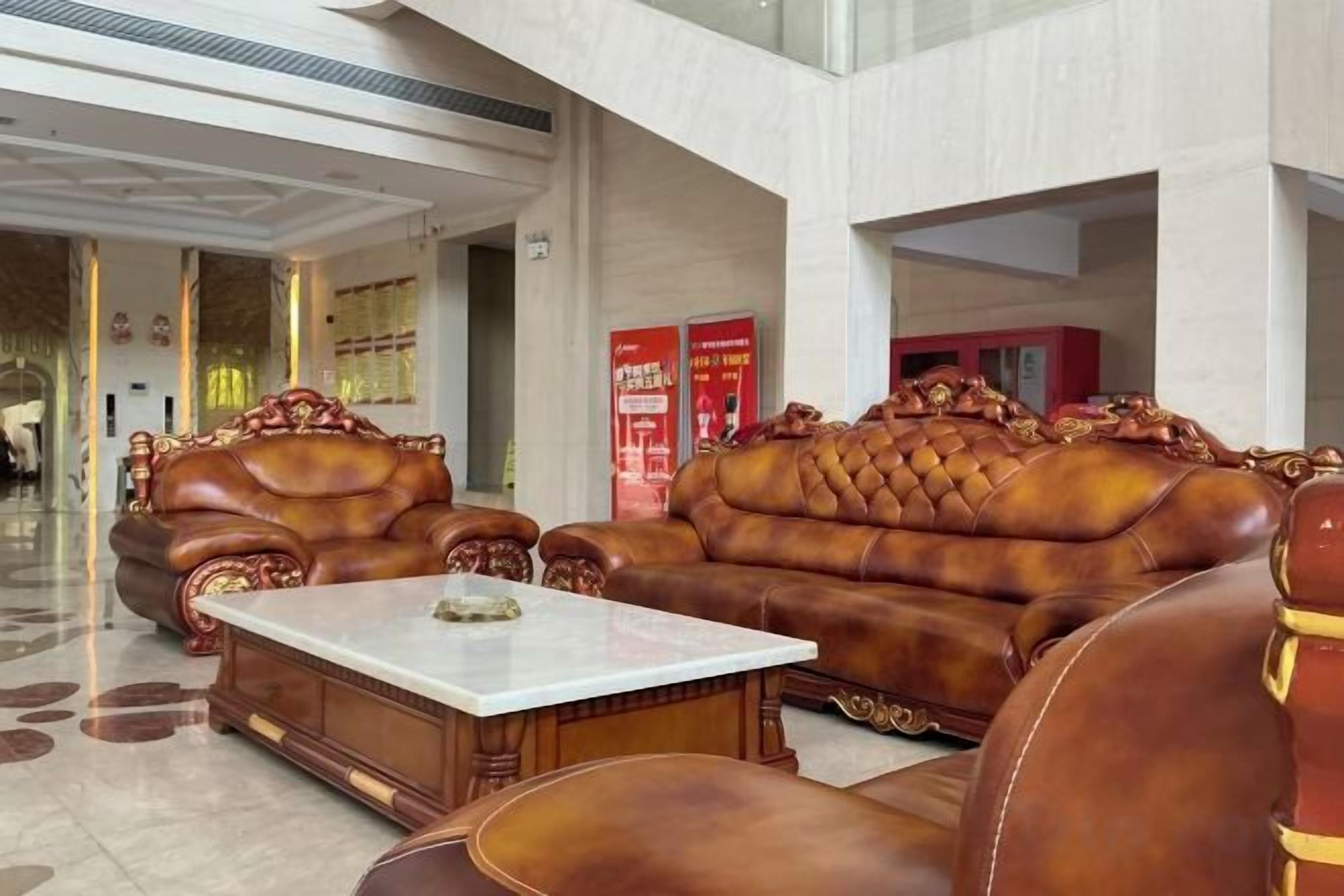 A lobby with leather sofas and a marble coffee table.