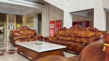 A lobby with leather sofas and a marble coffee table.