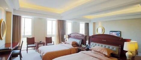 A hotel room with two beds, a desk, and a chair.