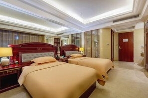 Ein Hotelzimmer mit zwei Betten, einem großen Spiegel und einem hölzernen Kopfteil.