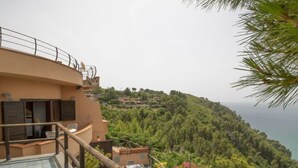 Eine Terrasse mit Blick auf eine Hügel- und Meereslandschaft.