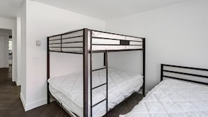 A bunk bed with a metal frame and white bedding in a room with white walls and wooden flooring. - Beautiful Ski-in/ski-out Condo Located On The Eagle Point Resort! 1 Bedroom Condo by RedAwning (Beaver)