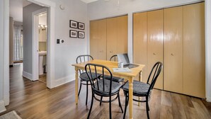 Un comedor con una mesa de madera y cuatro sillas, un ventilador de techo y un armario con puertas correderas.