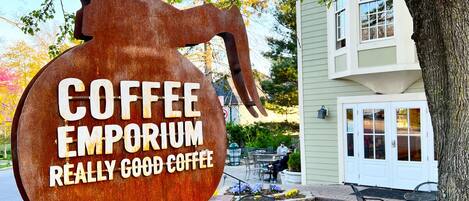 A sign for Coffee Emporium with a rustic design.