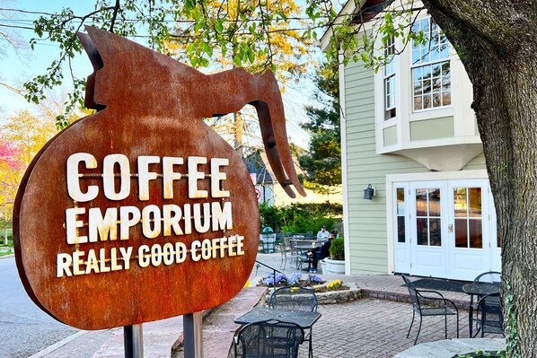 A sign for Coffee Emporium with a rustic design.