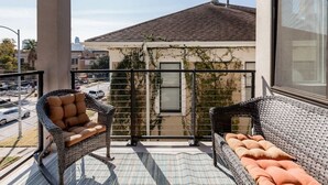 A balcony with wicker furniture and a view of a building with ivy. - Capitol View Condos by One Fine Bnb - Paramount (Austin)
