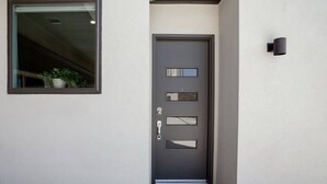 A modern door with a peephole and a small window above it. - Capitol View Condos by One Fine Bnb - Paramount (Austin)