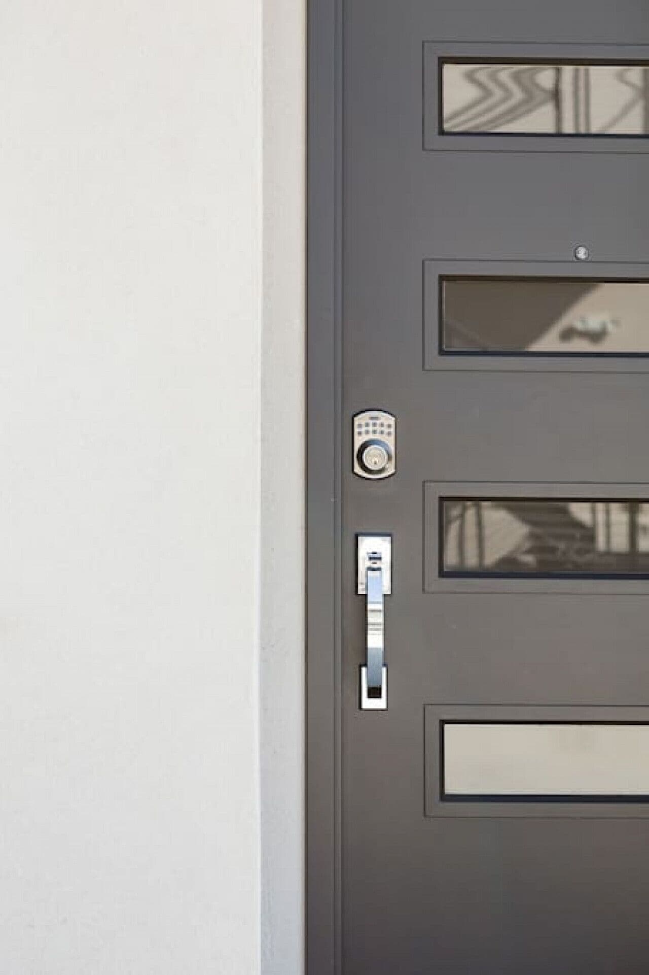 A gray door with a keypad lock, a card reader, and a mail slot.