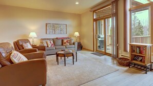 A spacious living room with a sofa, armchairs, a coffee table, and a bookshelf. - Prospector Point E 4br 3.5ba 4 Bedroom Townhouse by RedAwning (Frisco)